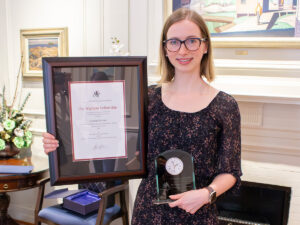 Jennifer farmer holding a framed copy of her wighton fellowship award